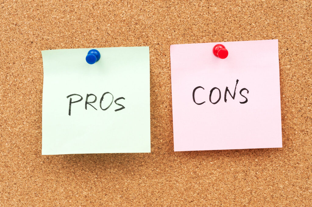 corkboard with green post it note "pros" and pink post it note "cons"